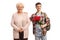 Teenage male student holding a bunch of red roses and standing next to an elderly woman