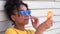 Teenage mixed race African American girl young woman wearing sunglasses reflecting blue sky and clouds using cell phone