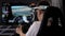 Teenage plays a racing car game in virtual reality glasses in front of a screen.