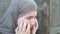 A teenage refugee girl is crying and screaming, holding her head in her hands, screaming in pain.