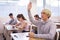 Teenage schoolboy raising hand to answer during lesson