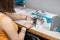 A teenage schoolgirl learns to sew protective masks on an overlock during a pandemic.