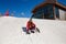 A teenage skier`s girlfriend sits on a mountainside