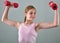 Teenage sportive girl is doing exercises to develop muscles on grey background. Sport healthy lifestyle concept. Sporty