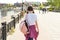 Teenage student girl walking down the street with backpack. Back to school, back view