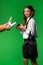 Teenage student takes protective mask and disinfect hands, green background