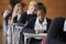 Teenage Students In Uniform Sitting Examination In School Hall