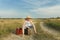 Teenage traveler waiting and sitting on luggage