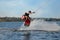 Teenage wakeboarder doing trick on river. Extreme water sport
