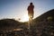 Teenager alone running in mountains with his headphones at the sunset - sport and athletic concept