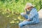 Teenager angler looking down at water from