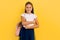 A teenager with a backpack and books. Stylish beautiful schoolgirl posing on a yellow background
