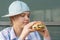 Teenager in a baseball cap eats a delicious juicy big burger