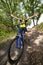 Teenager on a bicycle traveling in the forest