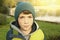 Teenager boy in autumn park in knitted green hat