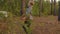 Teenager boy carrying timber log in coniferous forest. Young boy holding hard log for chopping in pine woodland.