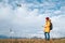 Teenager boy dressed yellow jacket piloting a modern digital drone using remote controller