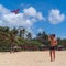 Teenager boy flying a kite on tropical beach