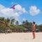 Teenager boy flying a kite on tropical beach