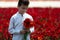 Teenager boy gathering a bouquet of flowers in the meadow on a sunny weather day for his mother