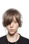 Teenager boy with hair over one eye and headphones