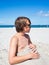 Teenager boy has fun digging in the sand at Baltic Sea