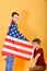 A teenager boy knelt in front of the American flag, young scouts patriots