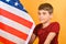 A teenager boy knelt in front of the American flag, young scouts patriots