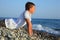 Teenager boy lying on stones on seacoast