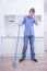 Teenager Boy Mopping The Floor and helps his parents to clean on kitchen