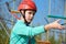 Teenager boy moves the vertical grid on the obstacle course in the amusement park, outdoor activities, rock climbing, danger, trai