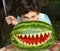 Teenager boy show monster with cut shark teeth water melong