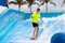 Teenager boy surfing in beach wave simulator