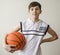 Teenager boy in a white shirt with a ball for basketball