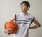 Teenager boy in a white shirt with a ball for basketball