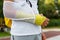 Teenager with broken arm next to the sports ground. The boy in a white t-shirt with a hand splint in an arm sling for support