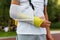 Teenager with broken arm next to sports ground. Boy in white t shirt with hand splint in a arm sling for support