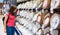 Teenager brunette girl in coral t-shirt with long hair choosing a dishes plate in supermarket store.