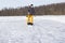 Teenager brush snow with shovel on ice of forest lake for ice skating. Healthy lifestyle