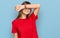 Teenager caucasian girl wearing casual red t shirt covering eyes with arm smiling cheerful and funny