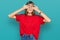 Teenager caucasian girl wearing casual red t shirt covering eyes with hands smiling cheerful and funny