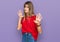 Teenager caucasian girl wearing casual red t shirt moving away hands palms showing refusal and denial with afraid and disgusting