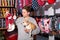 Teenager with chihuahua choosing clothes for dog in petshop