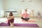 Teenager children sitting in lotus pose making yoga at home during coronavirus quarantine
