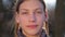 The teenager closes a hand lens of the camera. Portrait of a boy close-up, open and close the camera.