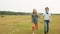 Teenager couple walking on rural field on haystack background. Happy teenagers girl and boy holding hands and walking on