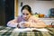 Teenager does her homework in the home kitchen on the table help