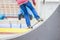 Teenager doing a trick by skateboard on a kicker in skate park