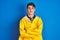 Teenager fisherman boy wearing yellow raincoat over  background happy face smiling with crossed arms looking at the camera