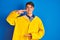 Teenager fisherman boy wearing yellow raincoat over isolated background gesturing with hands showing big and large size sign,